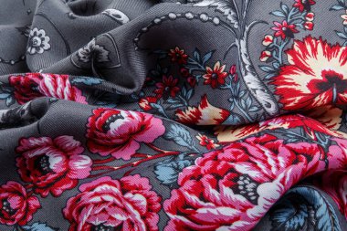 Üst taraf, buruşmuş koyu gri pamuklu kadın eşarbında parlak çiçekli ve büyük pembe güllü.