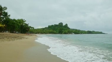 Yavaş yavaş kumsalın, tropikal ormanların ve yeşil uçurumların manzarası.