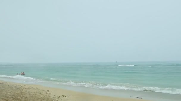 Snabbt panorama över blått hav med vita vågor och sandstrand vid tropiskt regn — Stockvideo