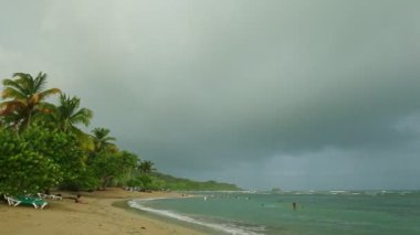 Güçlü beyaz dalgalarla mavi denizden altın kumsala