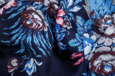 Üst görüntü koyu mavi pamuklu kadın şalının parlak çiçekli ve desenli büyük pembe, mor ve mavi güllü kısmı.