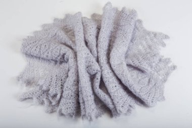 Üst görüntü katlanmış el yapımı gri yünlü eşarp ve açık gri arkaplan üzerine dizayn edilmiş eski Rus tarzı örgü desenli.