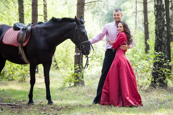 Casal feliz e cavalo — Fotografia de Stock