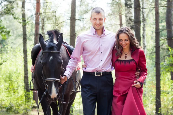 Casal feliz e cavalo — Fotografia de Stock