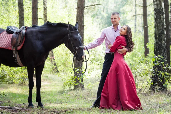 Счастливая пара и лошадь — стоковое фото