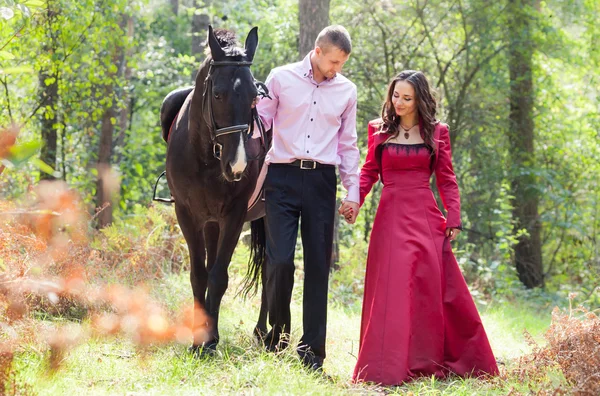 Casal feliz e cavalo — Fotografia de Stock