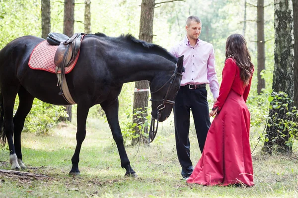 Jonge mooie brunette meisje in lange rode houden witte hakken schoenen — Stockfoto