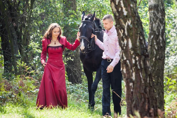 Casal feliz e cavalo — Fotografia de Stock