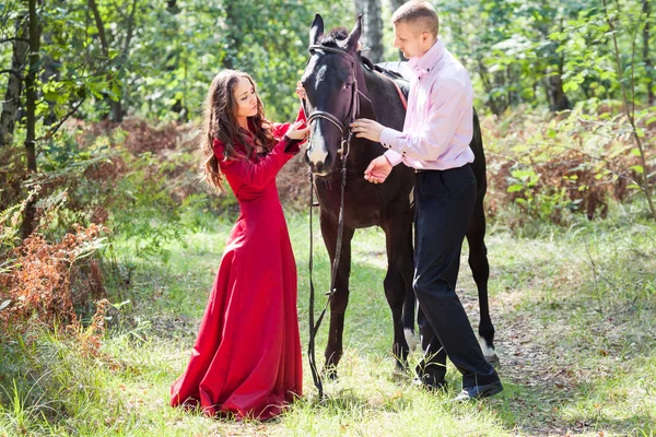 Lyckliga paret och häst — Stockfoto