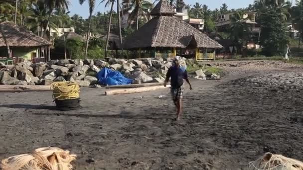 Pescador caminar sobre arena negra — Vídeo de stock