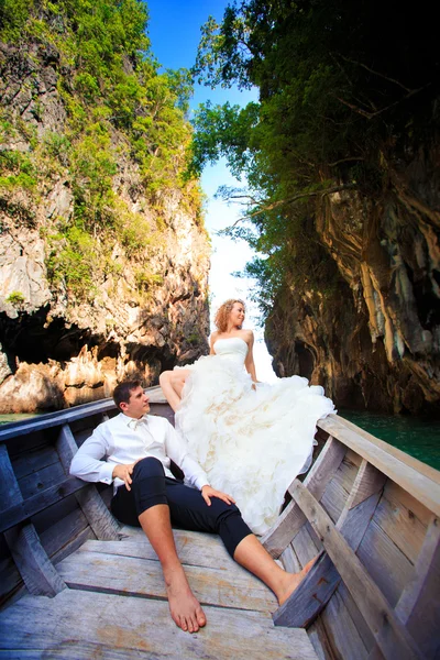 Blonde bride and handsome groom on boat — Stock Photo, Image