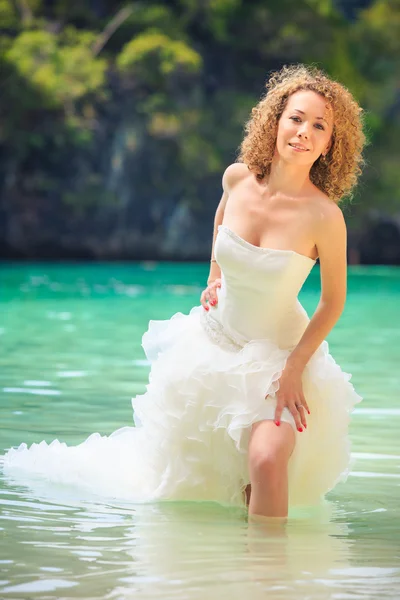 Blonde bride stand in seawater — Stock Photo, Image