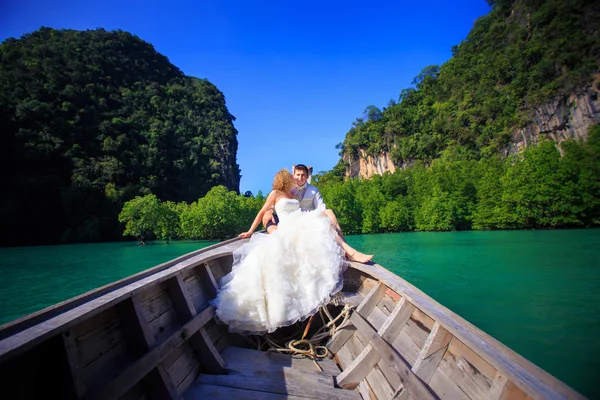 Blonde bride and handsome groom on boat — Stock Photo, Image