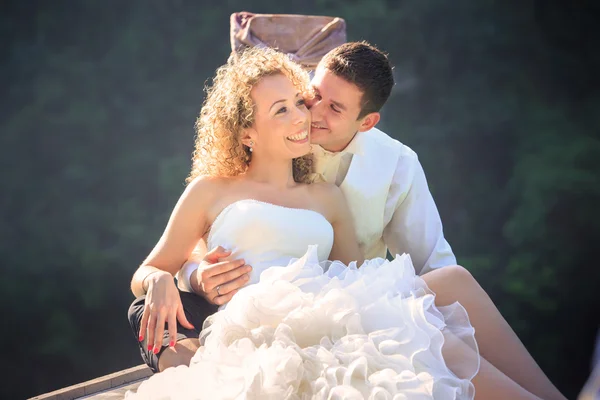 Blonde bride and handsome groom on boat — Stock Photo, Image