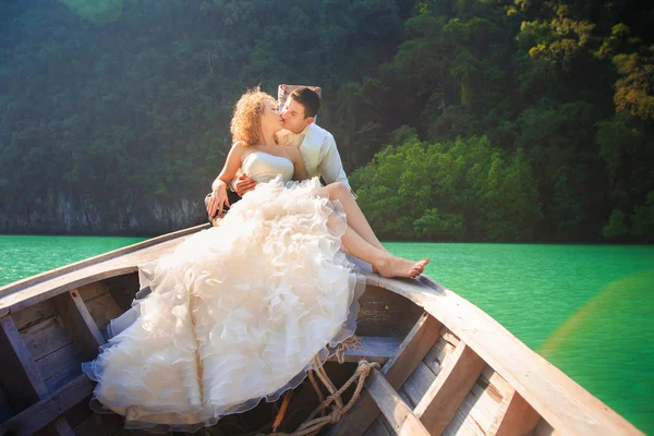 Blonde bride and handsome groom on boat — Stock Photo, Image