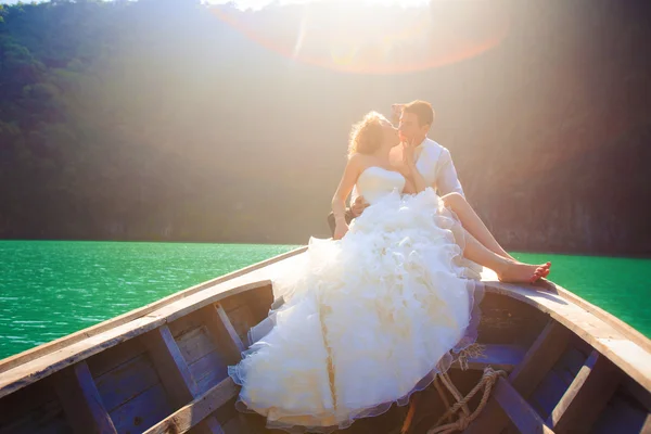 Blonde bride and handsome groom on boat — Stock Photo, Image