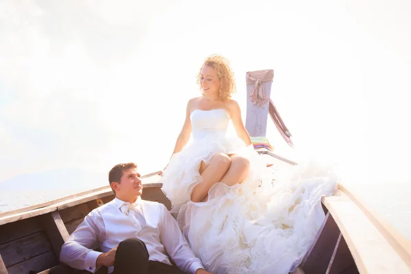 Blonde bride and handsome groom on boat — Stock Photo, Image