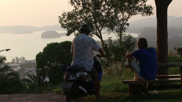 Mannen en scooter over zonsondergang — Stockvideo