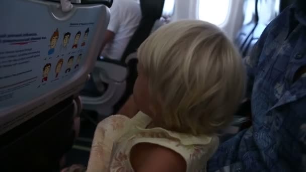 Маленькая девочка летит в самолете — стоковое видео