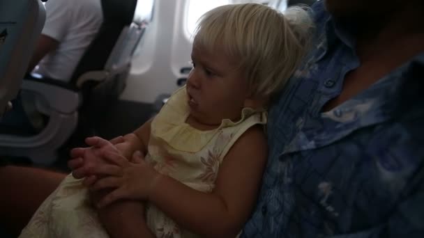 Маленькая девочка летит в самолете — стоковое видео