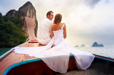 Gelin ve damat beyaz longtail teknede oturmak