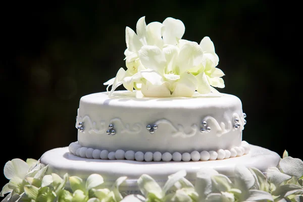 Большой свадебный торт с белыми орхидеями — стоковое фото