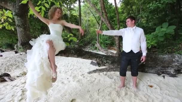 Невеста в платье и красивый жених на острове — стоковое видео