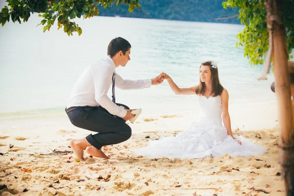 Giovani sposi sulla spiaggia sabbiosa dell'isola — Foto Stock