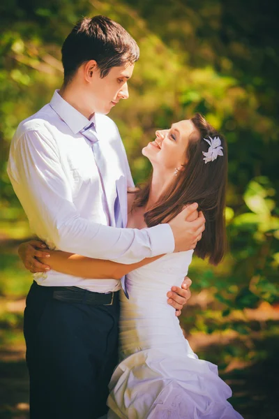 Bride and handsome groom embrace in jungle — Stock Photo, Image