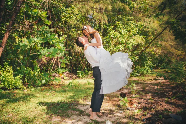 Braut und schöner Bräutigam umarmen sich im Dschungel — Stockfoto