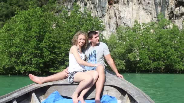 Девушка с парнем обнимается на лодке — стоковое видео