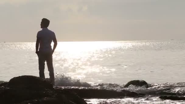 Jeune homme Silhouette sur rochers — Video