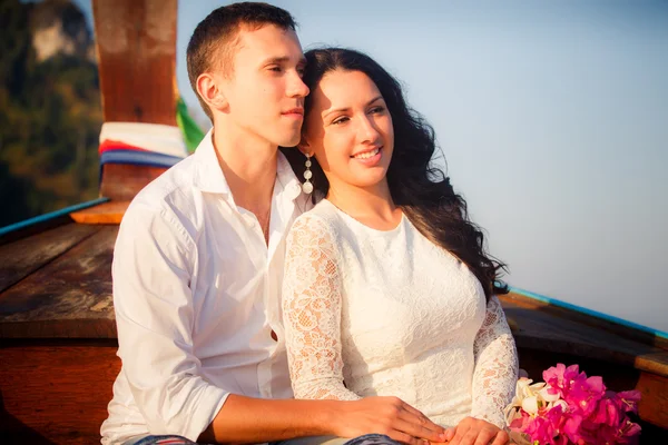 Bride and groom sit on longtail boat — Stock Photo, Image