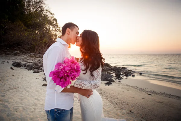 Sposa e sposo bacio in spiaggia all'alba — Foto Stock