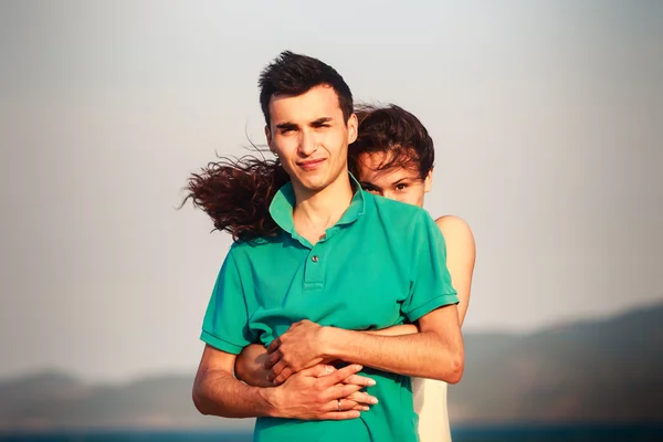 Girl and guy play against mountains — Stock Photo, Image