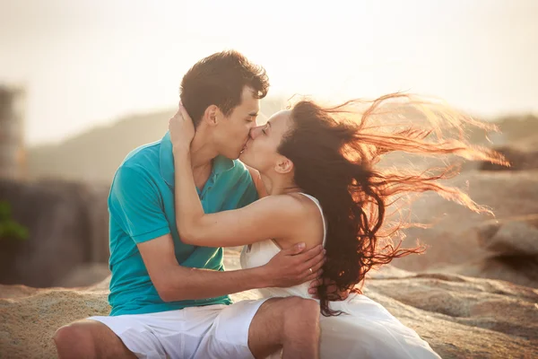 Chica y chico beso contra rocas — Foto de Stock