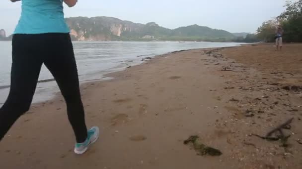 Frau läuft am Strand — Stockvideo