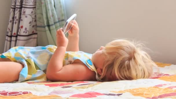 Petite fille joue avec smartphone — Video
