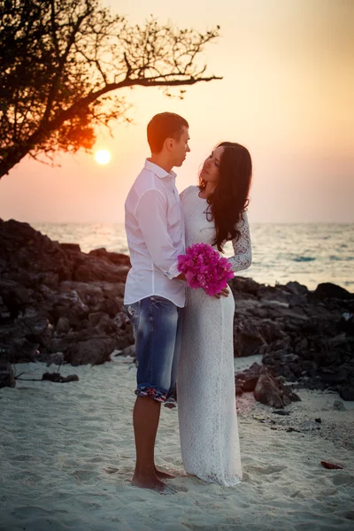 Bride and groom hug at  beach at sunrise — Stock Photo, Image