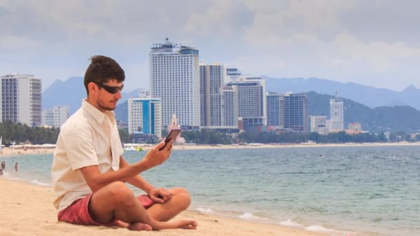 Stilig kille med telefon på stranden — Stockvideo