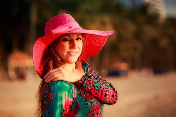 Portrait of slim girl in big red hat on beach — Stock fotografie