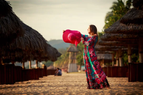 slim girl in red hat looks into sky among defocused umbrellas