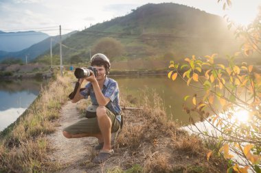 photographer squats makes photos among lakes