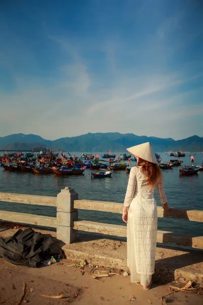 Blonde girl in Vietnamese dress backside view on embankment — Stock fotografie