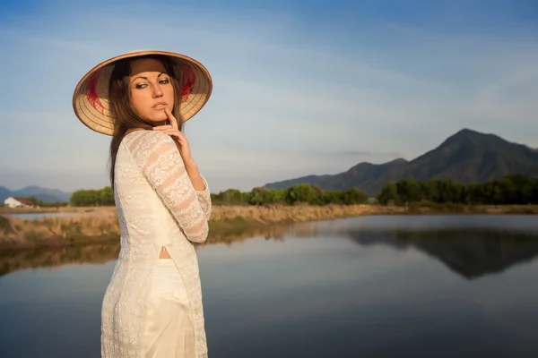 Portrait of girl in Vietnamese hat against country lakes — Stock Photo, Image