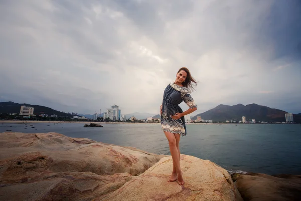 Young long-legged girl barefoot stands tiptoe against sea — Stock Photo, Image