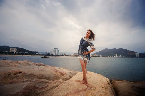 Young long-legged girl barefoot stands tiptoe against sea — Stock Photo, Image