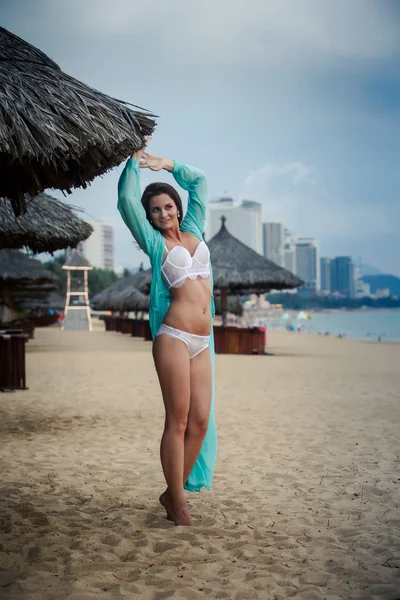 Mince fille en sous-vêtements jetés robe transparente ouverte sur le sable — Photo