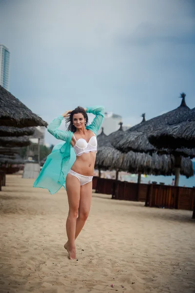 Slim girl in underwear thrown open transparent gown on beach — Stock Photo, Image