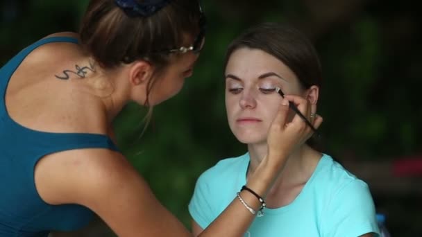 Стилист наносит макияж на лицо — стоковое видео
